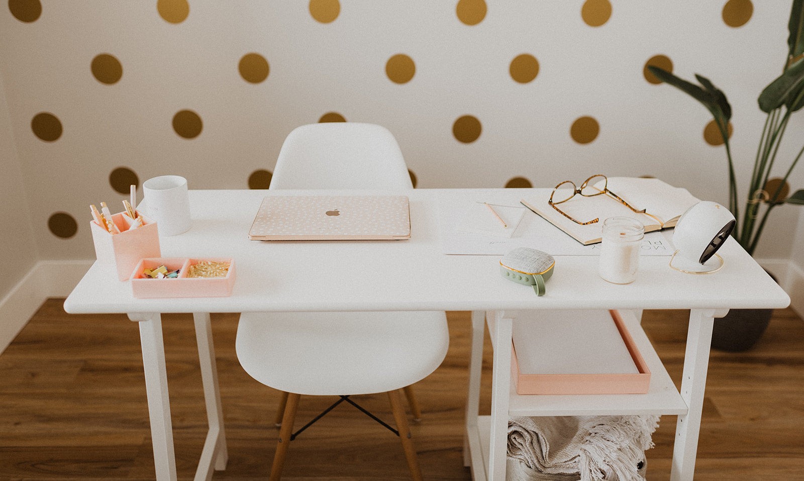 white desk, office chair and laptop in office with polka dot wallpaper