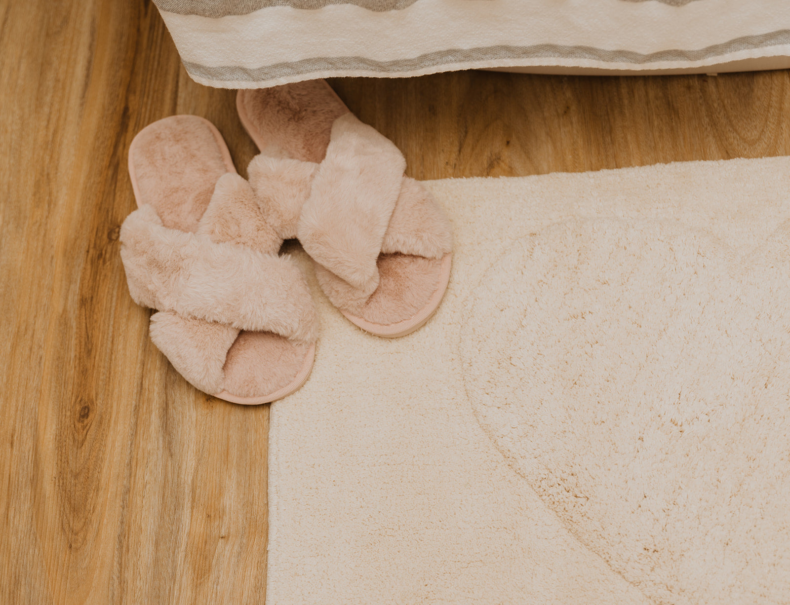 fluffy slippers on cream bath mat